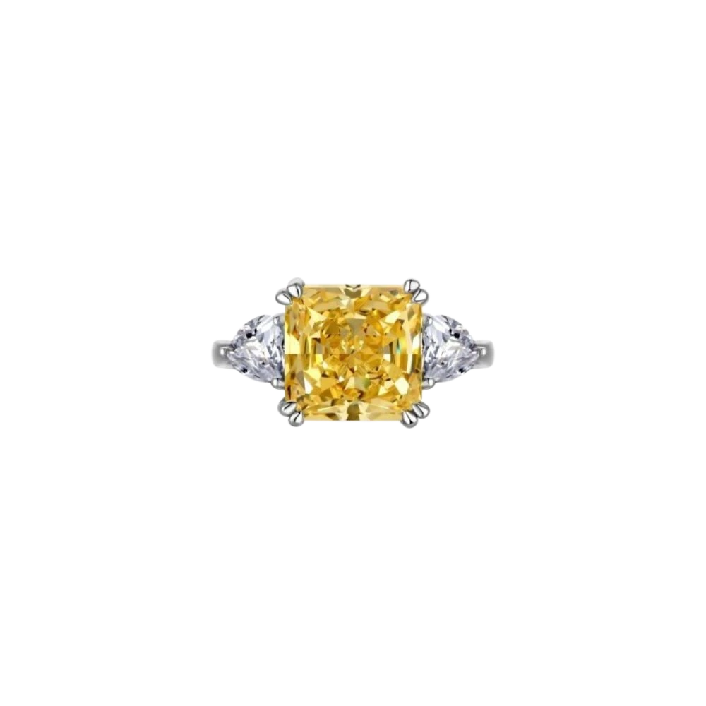 Anillo MANTO de AVA & SSILAQUÉ con un gran diamante amarillo central de talla radiante y dos diamantes blancos laterales de talla pera, en plata de ley con baño de rodio.