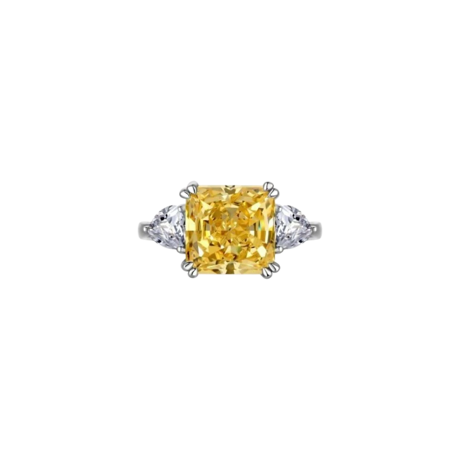 Anillo MANTO de AVA & SSILAQUÉ con un gran diamante amarillo central de talla radiante y dos diamantes blancos laterales de talla pera, en plata de ley con baño de rodio.