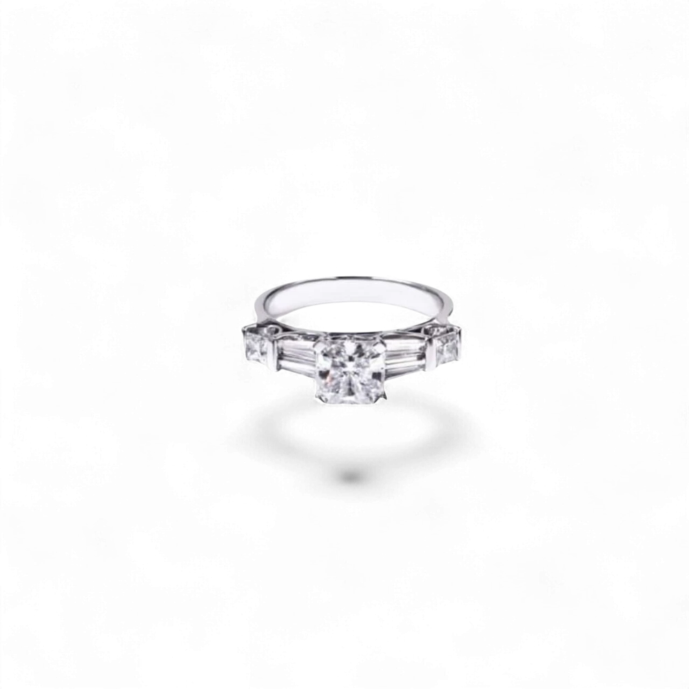 Anillo AVA & SSILAQUÉ de oro blanco de 14 quilates con un diamante radiante cuadrado central de 1 quilate y diamantes laterales princesa y trapecio.