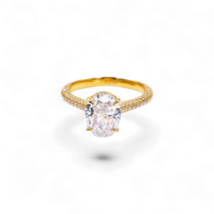Anillo de oro blanco de 14 quilates de AVA & SSILAQUÉ con un diamante ovalado central y gemas pavé en el aro.
