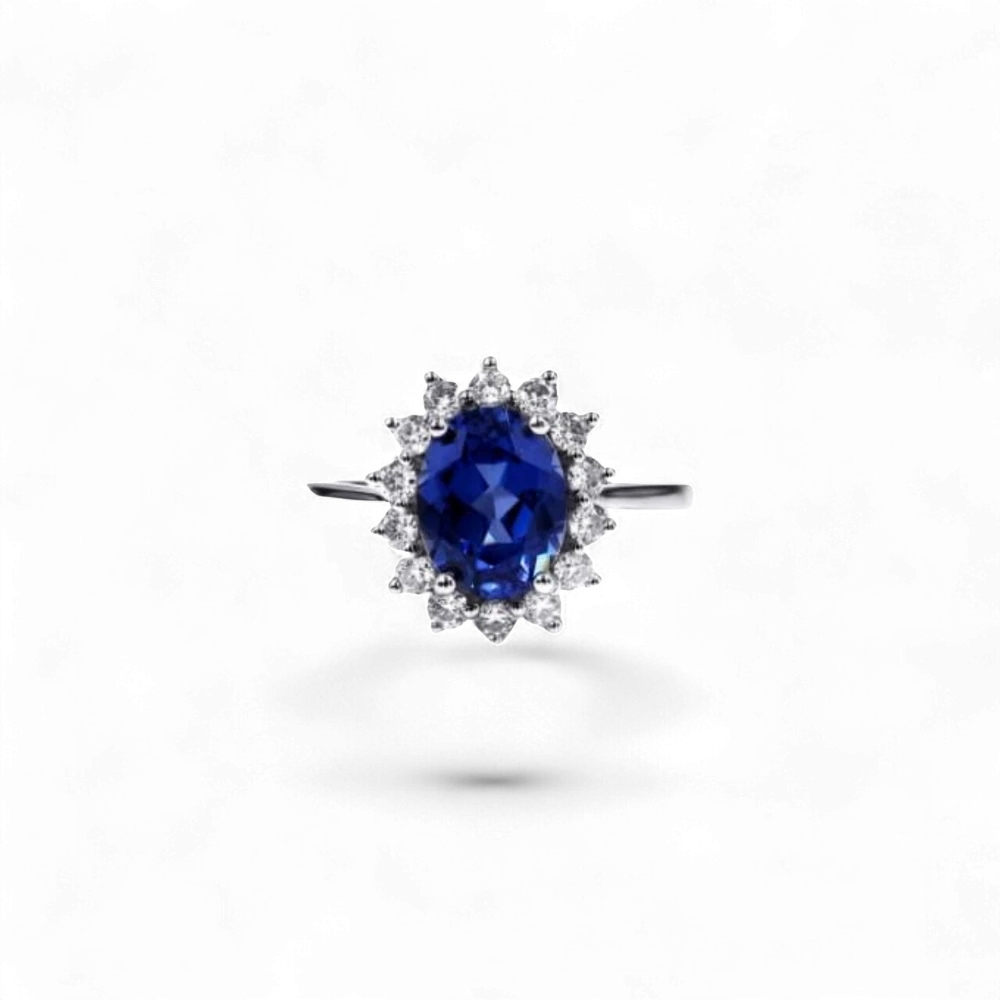 Anillo halo de oro blanco de 14K de AVA & SSILAQUÉ con un zafiro azul ovalado de 2,7 quilates rodeado de diamantes redondos.