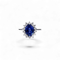 Anillo halo de oro blanco de 14K de AVA & SSILAQUÉ con un zafiro azul ovalado de 2,7 quilates rodeado de diamantes redondos.