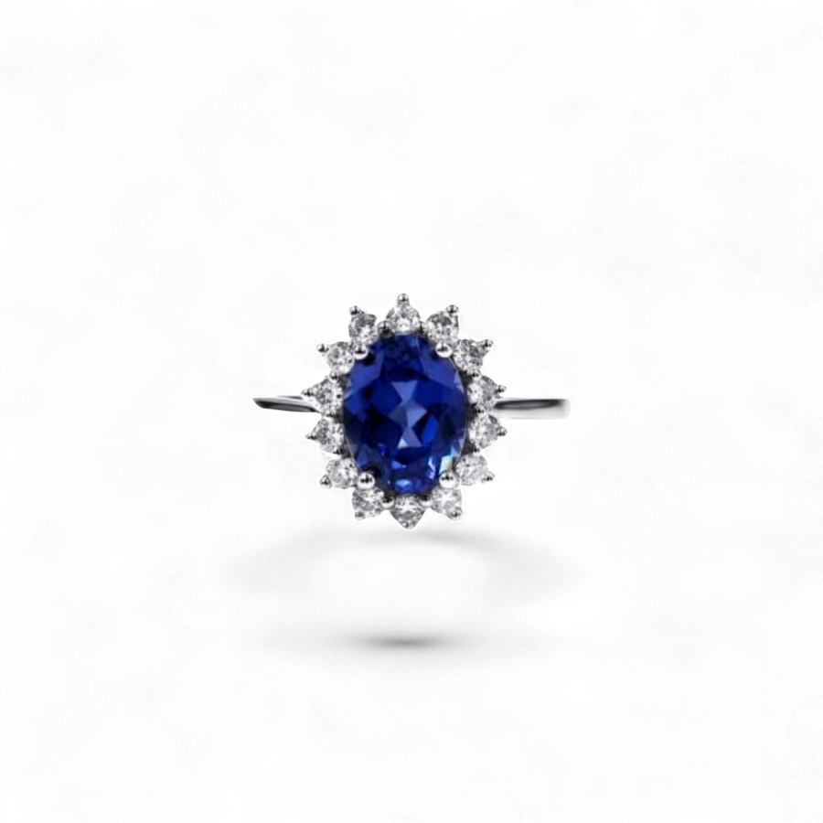 Anillo halo de oro blanco de 14K de AVA & SSILAQUÉ con un zafiro azul ovalado de 2,7 quilates rodeado de diamantes redondos.